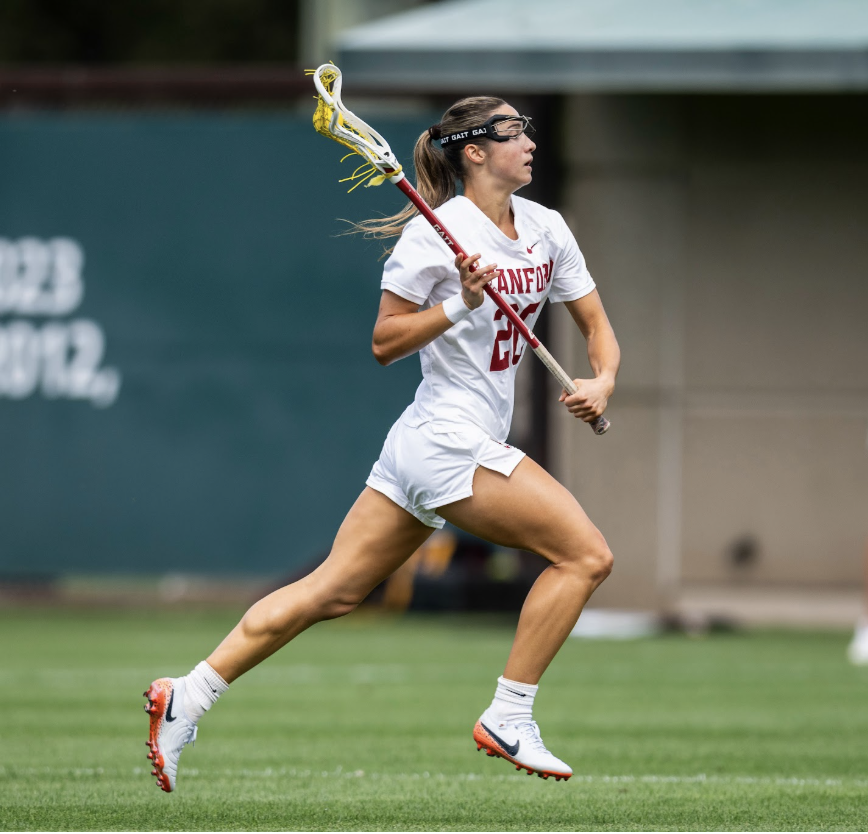 Anna Colpack running with a lacrosse stick during a Stanford game